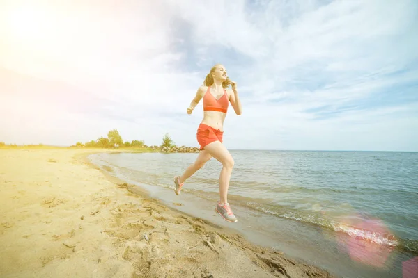 Giovane signora che corre alla soleggiata spiaggia di sabbia estiva. Allenati. Jogging — Foto Stock