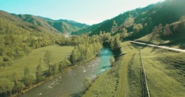 Taze dağ nehir ve güneşli yaz sabahı, çayır üzerinde havada uçuş. Kırsal toprak yol aşağıdaki.