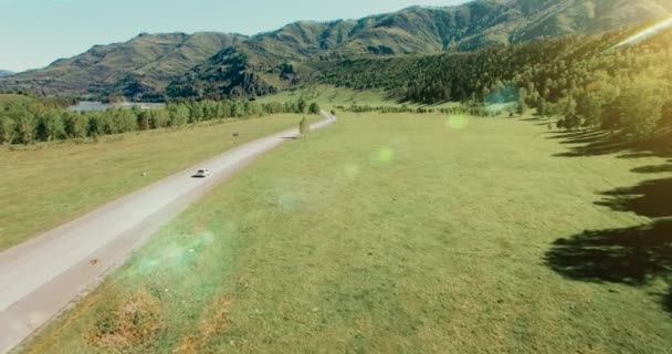 Survol de voitures sur une route sinueuse dans les collines et le pré. Autoroute rurale en dessous . — Video