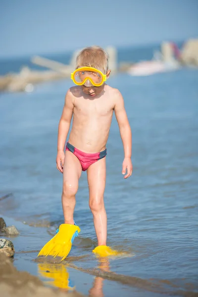 Lindo niño pequeño con máscara y aletas para bucear en la playa tropical de arena . — Foto de Stock