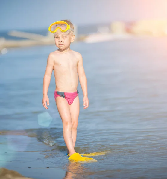 Lindo niño pequeño con máscara y aletas para bucear en la playa tropical de arena . — Foto de Stock