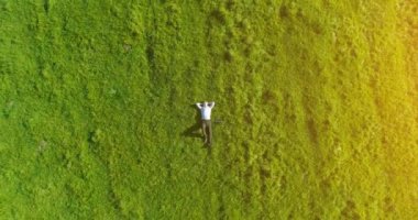 Taze yeşil çayır üzerinde yalan işadamı üzerinde dikey hareket uçuş. Üstten Görünüm üzerinde rahatlatıcı dostum.