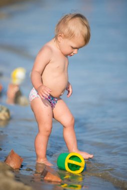 Şirin Bebek kumlu plajı ve deniz suyu oynarken.