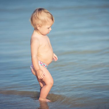Şirin Bebek kumlu plajı ve deniz suyu oynarken.