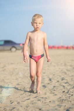 Kumsal deniz kenarında yürürken erkek sevimli bebek. Okyanus kıyısı.