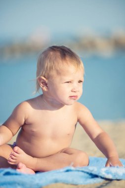 Şirin Bebek denize yakın kum plajındaki oyuncaklar ile oynama.