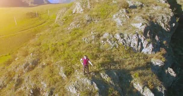Воздушный UHD 4K полет от молодого туриста, стоящего на вершине скалы — стоковое видео