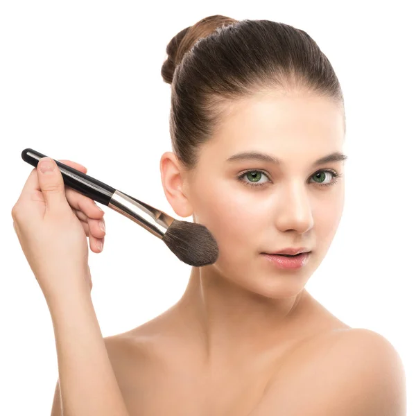 Ung brunett kvinna med rena ansikte. Flicka perfekt hud tillämpa kosmetiska borste. Isolerad på en vit. — Stockfoto