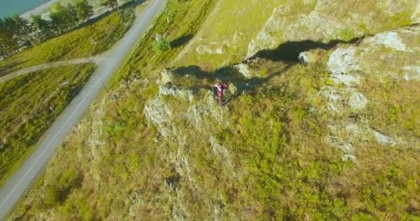 Volo radiale orbitale attorno al giovane escursionista in piedi sulla scogliera. Distoglie lo sguardo . — Video Stock