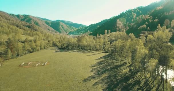 Vista aerea UHD 4K. Basso volo sul fresco fiume di montagna freddo, prato e strada al sole mattina d'estate . — Video Stock