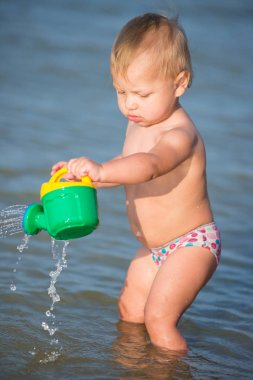 Şirin Bebek kumlu plajı ve deniz suyu oynarken.