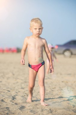 Kumsal deniz kenarında yürürken erkek sevimli bebek. Okyanus kıyısı.