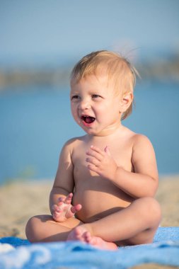 Şirin Bebek denize yakın kum plajındaki oyuncaklar ile oynama.