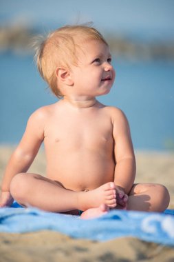 Şirin Bebek denize yakın kum plajındaki oyuncaklar ile oynama.