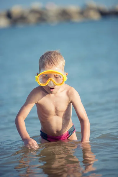 Lindo niño pequeño con máscara y aletas para bucear en la playa tropical de arena . — Foto de Stock