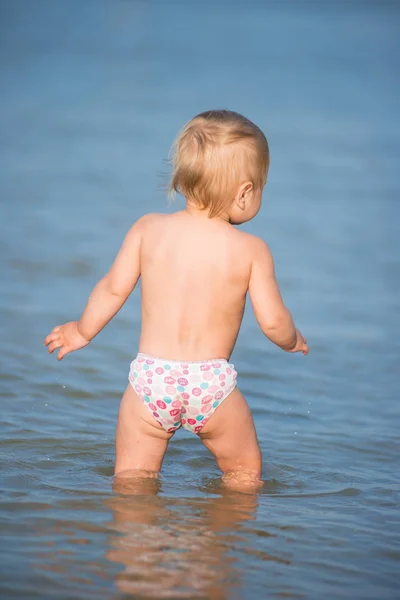 Carino bambino che gioca sulla spiaggia di sabbia e in acqua di mare . — Foto Stock