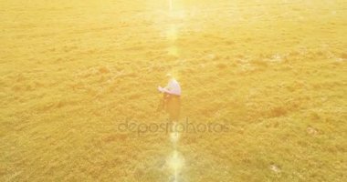 UHD 4k havadan görünümü. Defter pad ile yeşil çim sahasında oturan işadamı üzerinde düşük yörünge uçuş