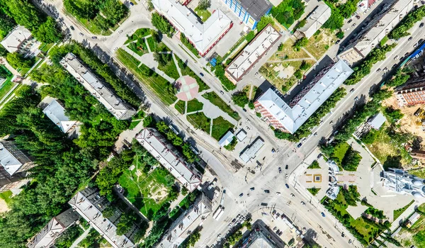 Vista aérea de la ciudad con encrucijadas y caminos, casas, edificios, parques y estacionamientos. Imagen panorámica soleada de verano —  Fotos de Stock