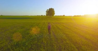 UHD 4k havadan görünümü. Alçak irtifa uçuş kırsal alan, sportif kadının önünde