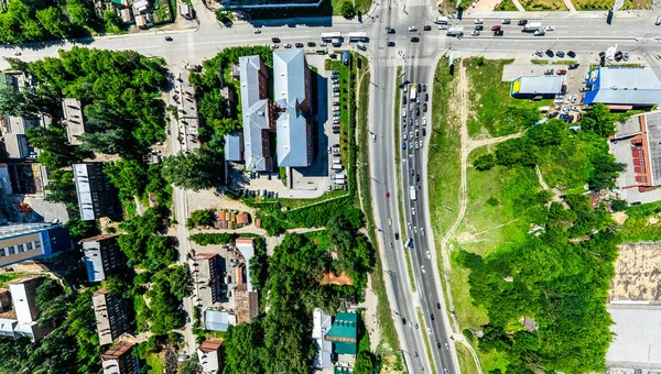 Vista aérea de la ciudad con encrucijadas y caminos, casas, edificios, parques y estacionamientos. Imagen panorámica soleada de verano —  Fotos de Stock