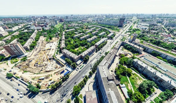 Vista aérea de la ciudad con encrucijadas y caminos, casas, edificios, parques y estacionamientos. Imagen panorámica soleada de verano —  Fotos de Stock