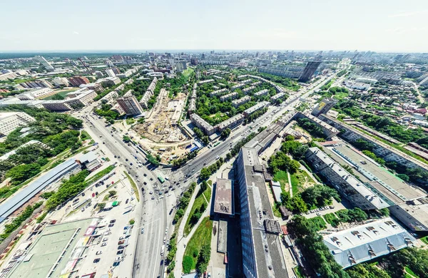 Vista aérea de la ciudad con encrucijadas y caminos, casas, edificios, parques y estacionamientos. Imagen panorámica soleada de verano — Foto de Stock