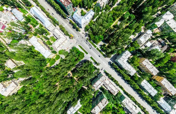 Vista aérea de la ciudad con encrucijadas y caminos, casas, edificios, parques y estacionamientos. Imagen panorámica soleada de verano —  Fotos de Stock