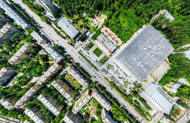 Kesişen yollar, evler, binalar, parklar ve otoparklar olan havacılık şehri manzarası. Güneşli yaz panoramik resmi