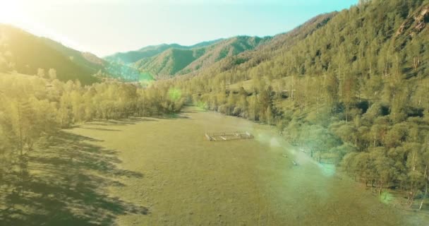 Vista aerea UHD 4K. Basso volo sul fresco fiume di montagna freddo, prato e strada al sole mattina d'estate . — Video Stock