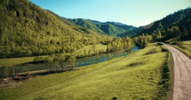 到 4k 的鸟瞰图。低飞行在新鲜冷山河流、 草地和公路在晴朗的夏日早晨. — 图库视频影像