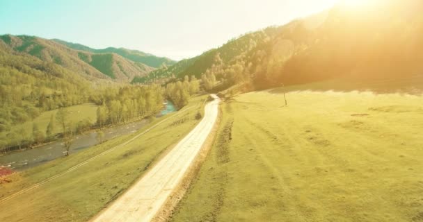 Luchtfoto van de Uhd 4k. Lage air-vlucht over landelijke vuil bergweg en weide — Stockvideo