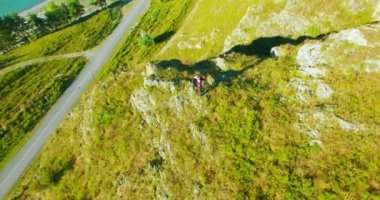Genç yürüyüş adam uçurumun üstünde ayakta çevresinde yörünge Radyal uçuş. Uzakta görünüyor.