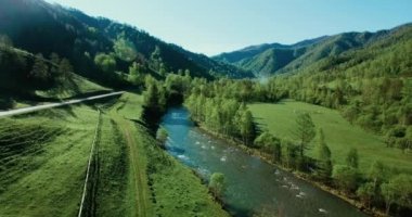 Taze dağ nehir ve güneşli yaz sabahı, çayır üzerinde havada uçuş. Kırsal toprak yol aşağıdaki.