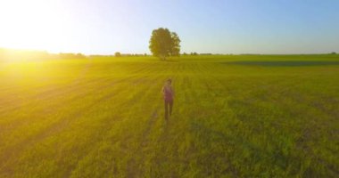 UHD 4k havadan görünümü. Alçak irtifa uçuş kırsal alan, sportif kadının önünde