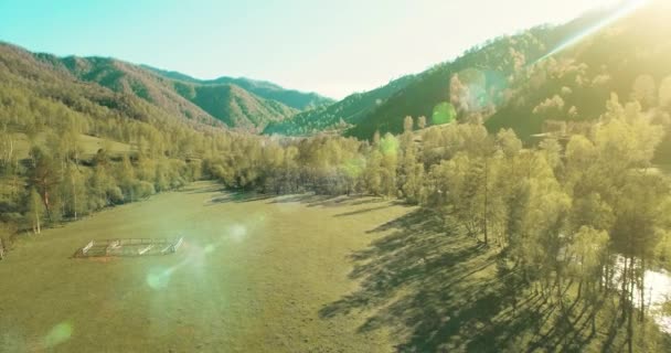 UHD 4k luchtfoto. Lage vlucht over verse koude berg rivier, weide en weg bij zonnige Zomerochtend. — Stockvideo