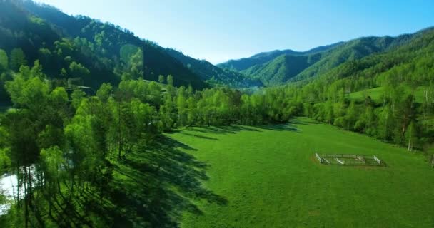 Widok z lotu ptaka UHD 4k. Niski Lot nad zimnej górskiej rzeki, łąka i road w słoneczny letni poranek. — Wideo stockowe