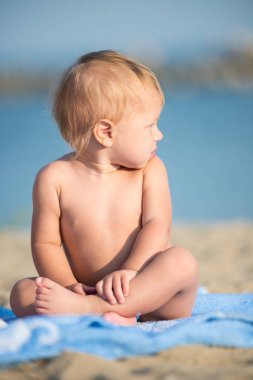 Şirin Bebek denize yakın kum plajındaki oyuncaklar ile oynama.