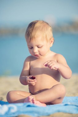 Şirin Bebek denize yakın kum plajındaki oyuncaklar ile oynama.