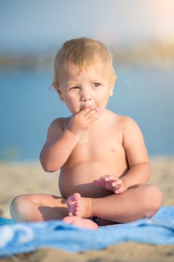 Şirin Bebek denize yakın kum plajındaki oyuncaklar ile oynama.