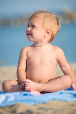 Şirin Bebek denize yakın kum plajındaki oyuncaklar ile oynama.