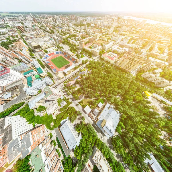 Aerial city view with crossroads and roads, houses, buildings, parks and parking lots. Sunny summer panoramic image — Stock Photo, Image