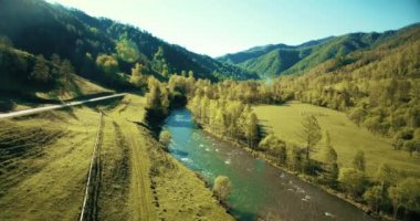 Taze dağ nehir ve güneşli yaz sabahı, çayır üzerinde havada uçuş. Kırsal toprak yol aşağıdaki.