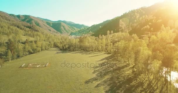 UHD 4K vista aérea. Vuelo bajo sobre el río fresco y frío de la montaña, prado y carretera en la soleada mañana de verano . — Vídeos de Stock