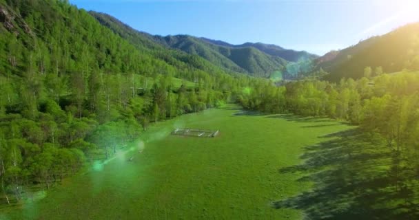 UHD 4K vista aérea. Vuelo bajo sobre el río fresco y frío de la montaña, prado y carretera en la soleada mañana de verano . — Vídeos de Stock