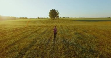 UHD 4k havadan görünümü. Alçak irtifa uçuş kırsal alan, sportif kadının önünde