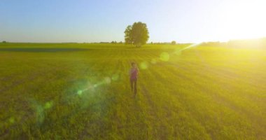 UHD 4k havadan görünümü. Alçak irtifa uçuş kırsal alan, sportif kadının önünde