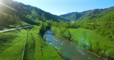 Taze dağ nehir ve güneşli yaz sabahı, çayır üzerinde havada uçuş. Kırsal toprak yol aşağıdaki.