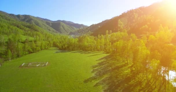 UHD 4K vista aérea. Vôo baixo sobre o rio frio fresco da montanha, o prado e a estrada na manhã ensolarada do verão . — Vídeo de Stock