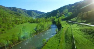 Taze dağ nehir ve güneşli yaz sabahı, çayır üzerinde havada uçuş. Kırsal toprak yol aşağıdaki.