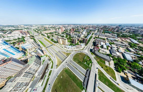 Vista aérea de la ciudad con encrucijadas y caminos, casas, edificios, parques y estacionamientos. Imagen panorámica soleada de verano —  Fotos de Stock